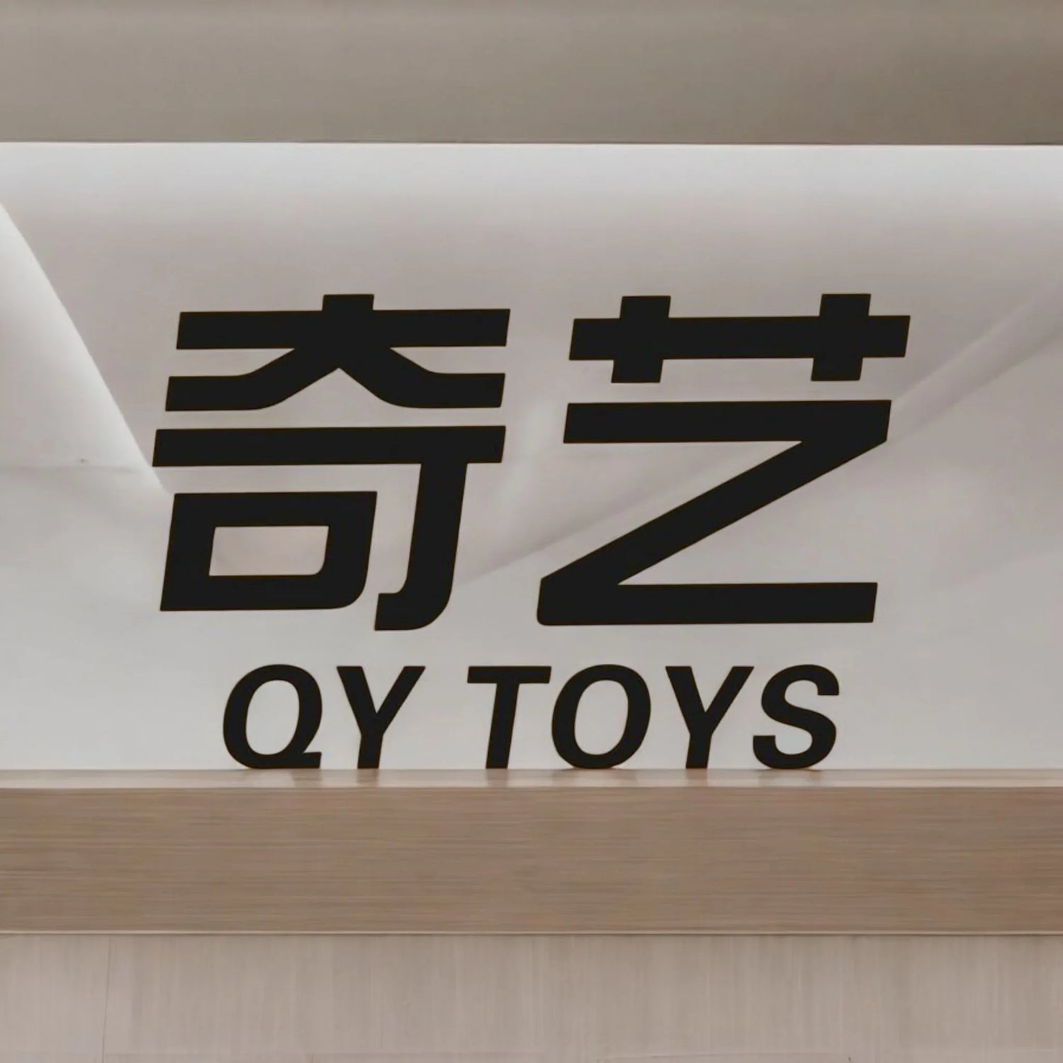 Letrero de tienda QY TOYS con caracteres chinos en pared blanca