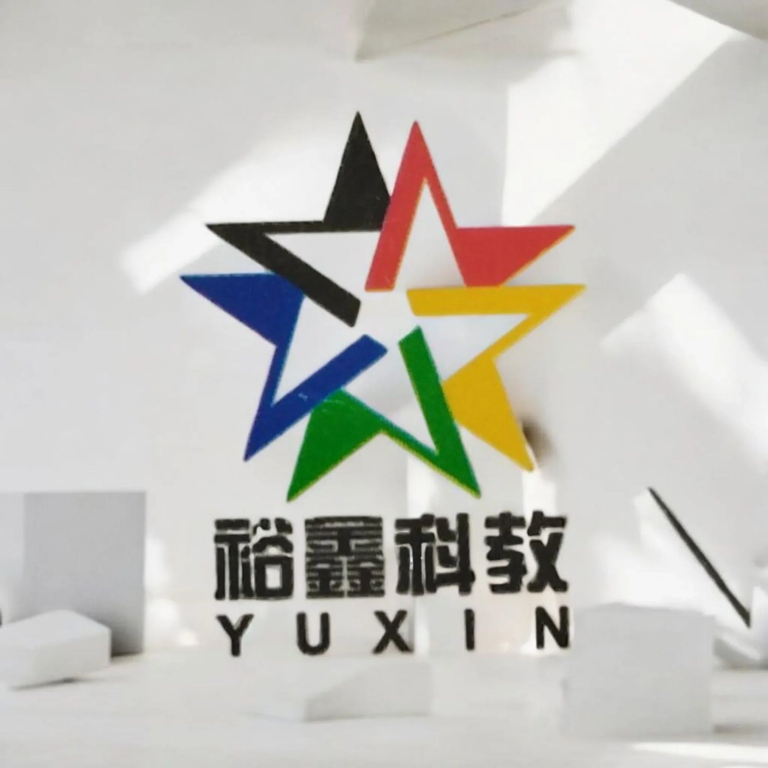 Logo de la marca Yuxin con estrella multicolor sobre fondo blanco